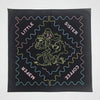 Screen printed design on blue fabric with text and character illustration.